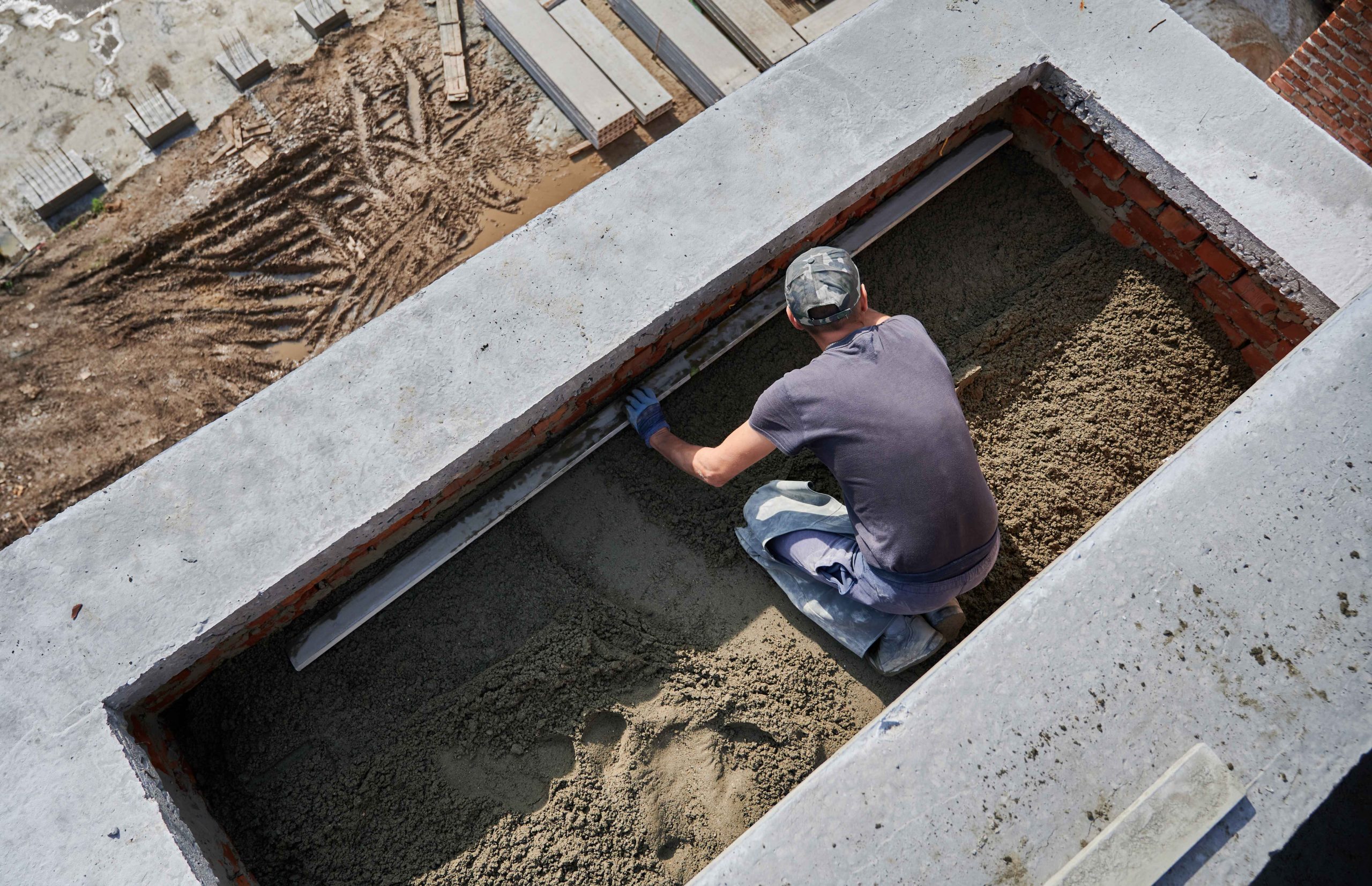 male-worker-screeding-floor-construction-site_11zon